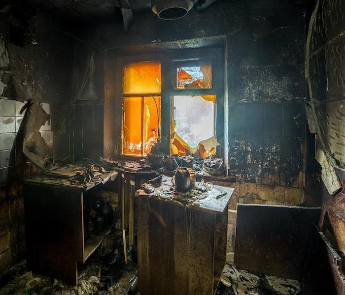 a small interior room showing extensive damage from a recent fire