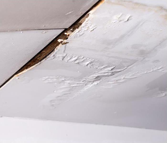 A white ceiling showing signs of water damage from a leak.